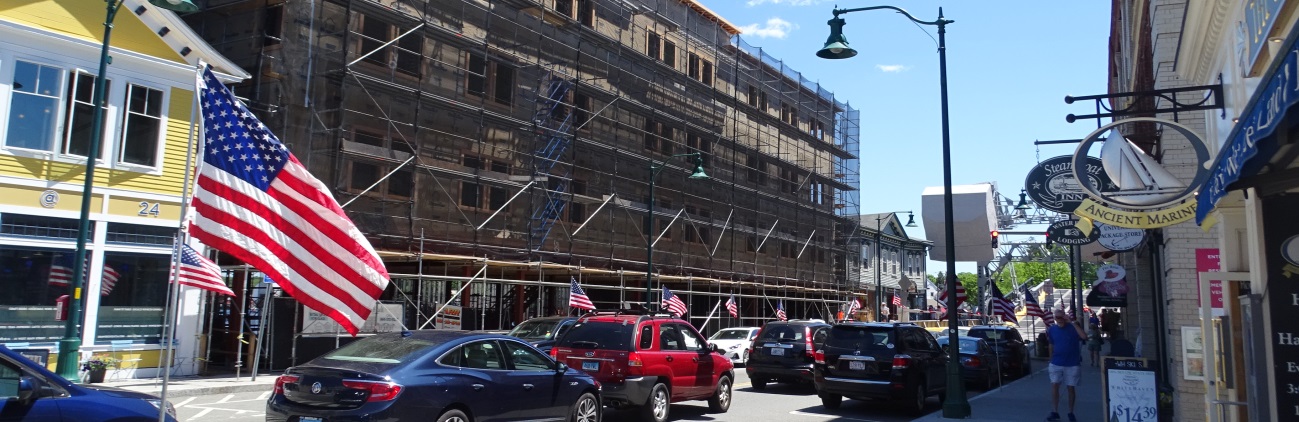 Street scene with a building under construction, wrapped in scaffolding.